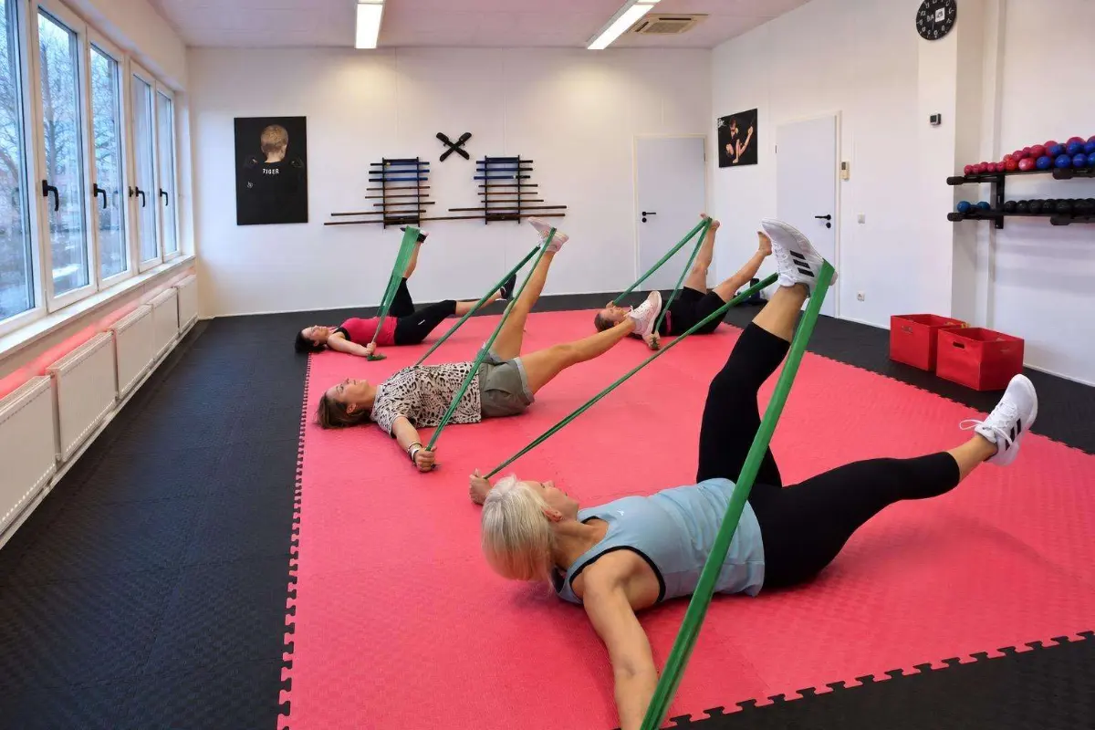 Beintraining mit Fitnessbändern auf der Matte beim Full Body Workout