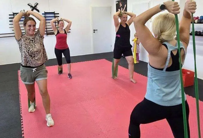 Lachende Teilnehmerinnen beim Training mit Fitnessbändern